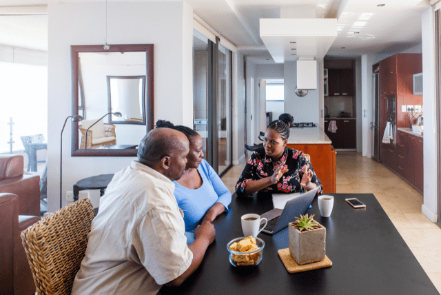 African American Couple and Woman Discussion at kitchen table with computer