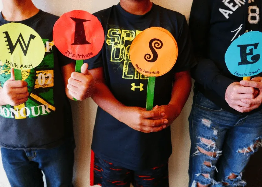 Kids holding up different color paper cut outs W.I.S.E. for W.I.S.E. Up!