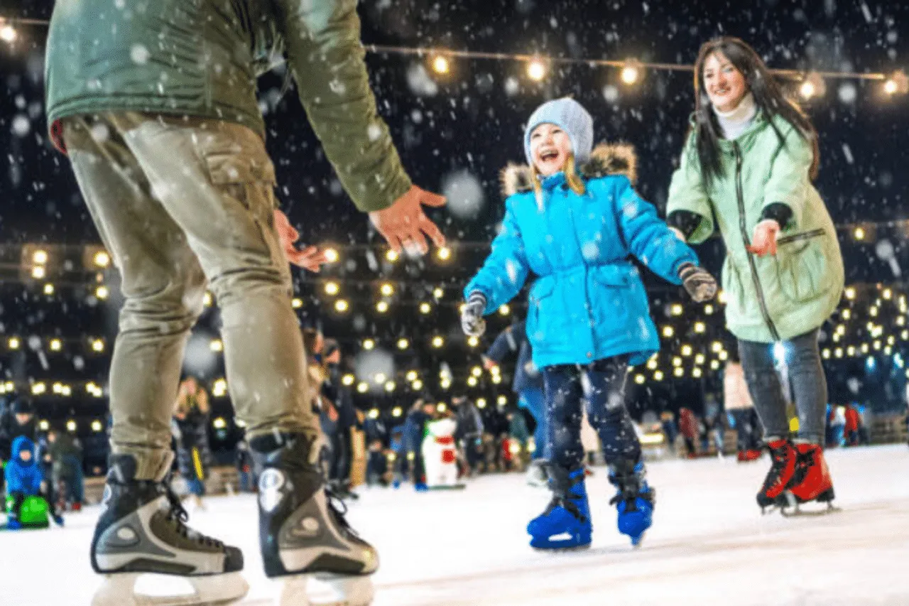 Young girl with parents ice skating and smiling