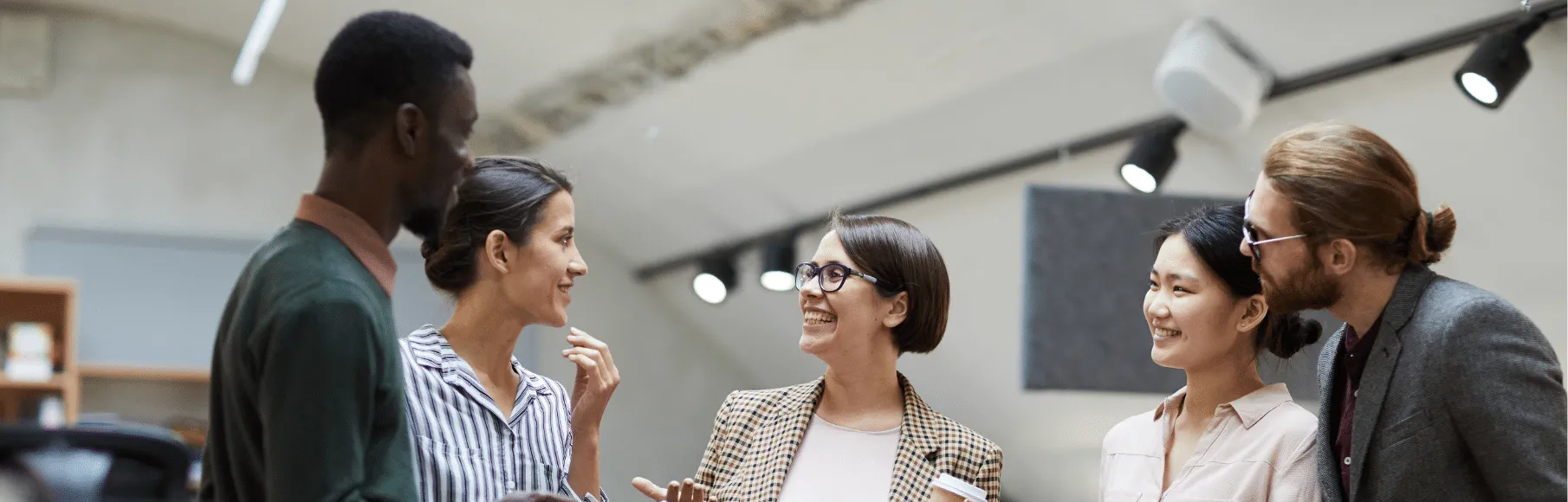 Social workers standing, smiling talking together in an office setting