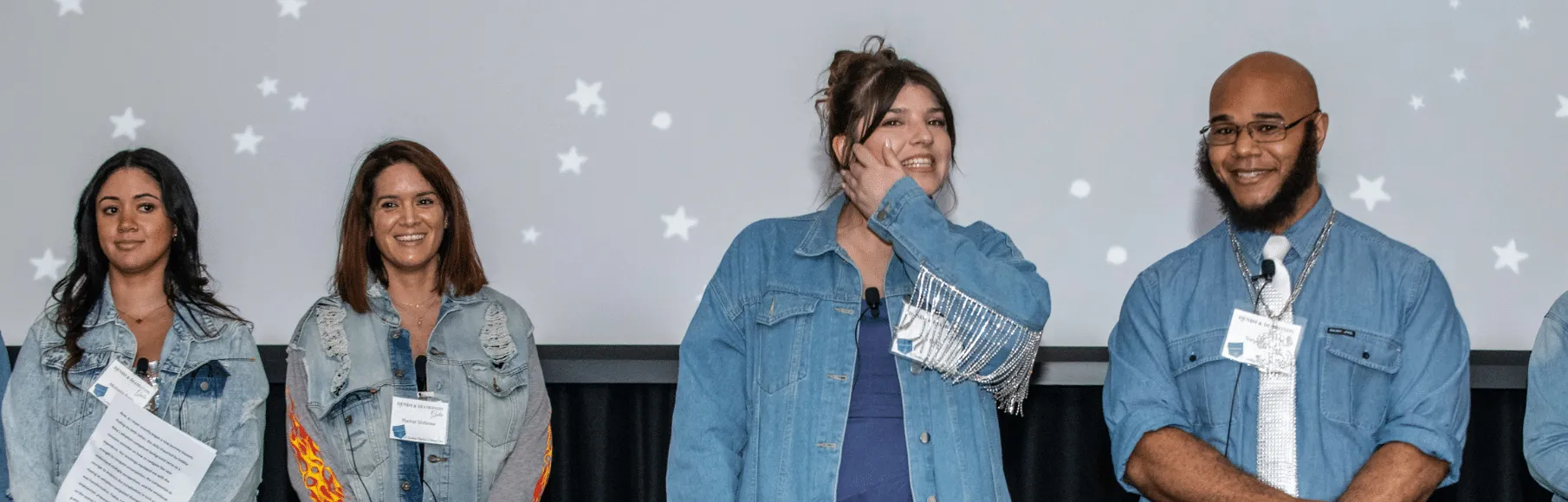Michaela Battle and Rachel Shifaraw smiling in background looking at Zoe Bulitt and Tony Parson smiling on stage