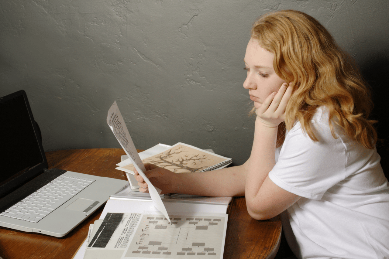 Teen girl looking at a genealogy paper