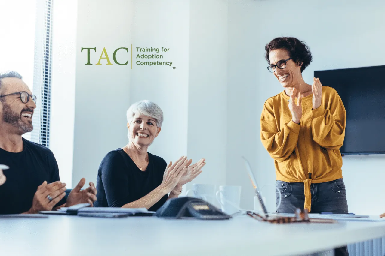 Professionals smiling and clapping in conference room setting, TAC logo overlay