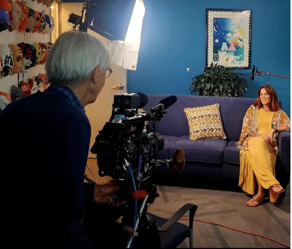 Behind the scenes of filming - Rachel Shifaraw smiling and looking at masks on wall