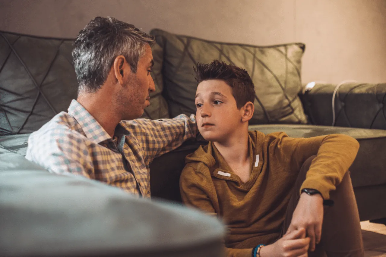 Dad and son talking on floor in living room