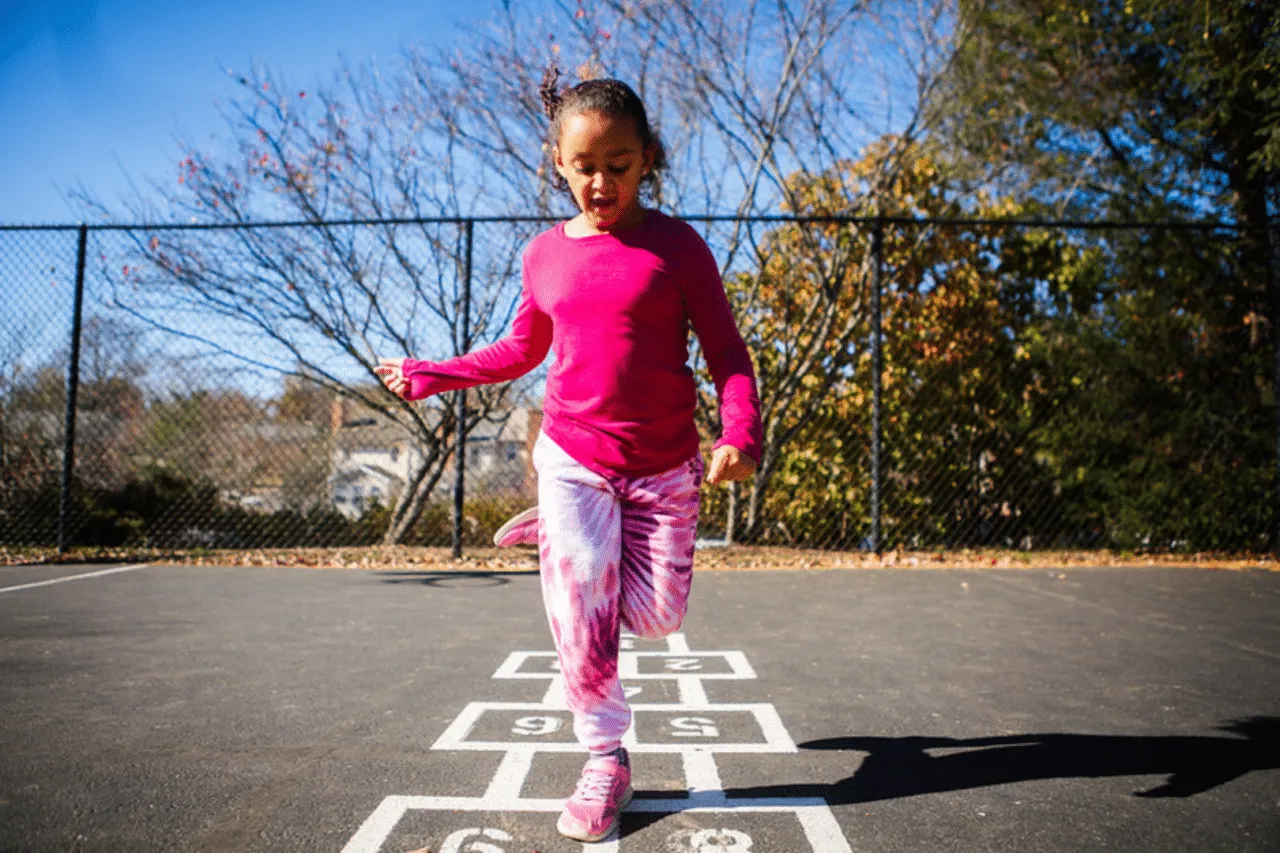 Young Girl Playing Hopscotch