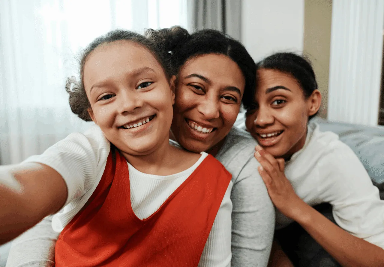 Kinship caregiver smiling with two kinship girl family members