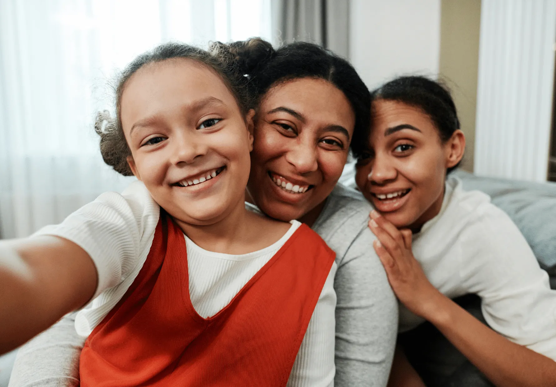 Kinship caregiver smiling with two kinship girl family members