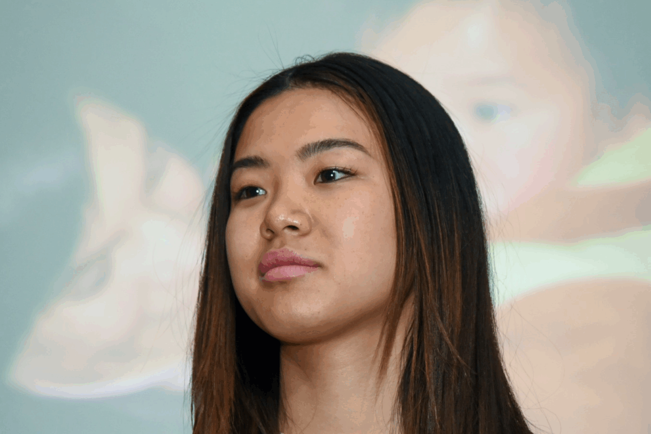 Zoe Evans staring serious with image of her mother and herself in background