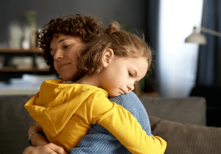 Adoptive mother hugging sad adoptive daughter