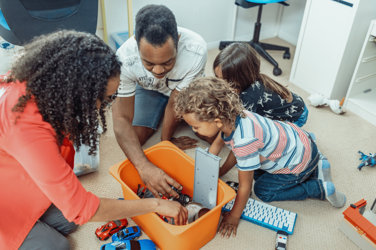 Foster parents playing in toy box with foster children