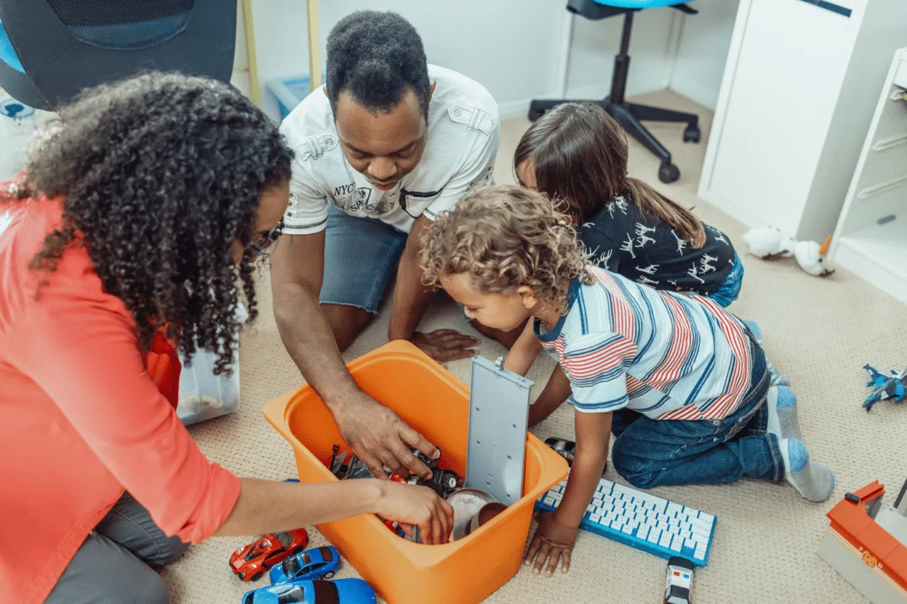 Foster parents playing in toy box with foster children